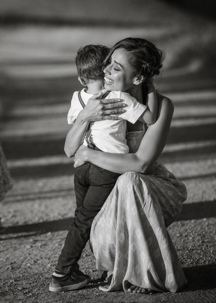 Mother and little boy embrace during sunset photo session